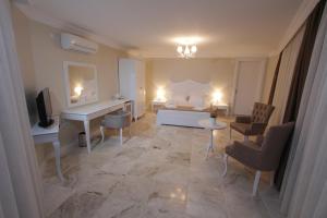 sala de estar con cama, mesa y sillas en Alaçatı Çınar Boutique Hotel, en Alacati