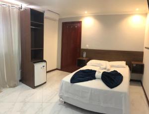 a bedroom with a large bed and a television at Canto da Praia Suítes in Arraial do Cabo +68 photos