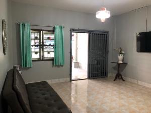 a living room with a couch and a sliding glass door at Pani House Hatyai 1 in Hat Yai