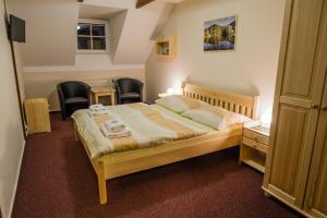 a bedroom with a bed with two towels on it at Penzion U Candru in Vyšší Brod