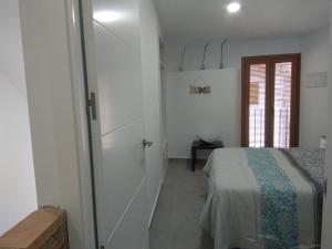 - une chambre avec un lit et une porte menant à une pièce dans l'établissement Caleros 8 Apartamento - Apartamentos de la Parte Antigua de Cáceres, à Cáceres