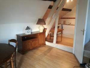 een woonkamer met een tafel en een kamer met een trap bij Anim'O Perch' & Gîtes (AOPEG) in Mézières-au-Perche