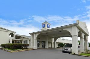 un coche aparcado frente a un edificio con una torre de reloj en Americas Best Value Inn Beaumont, en Beaumont