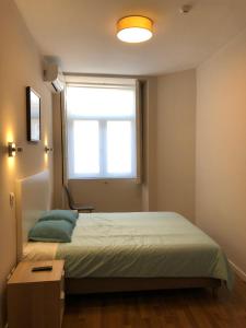 a bedroom with a large bed and a window at HaoBo Porto Center in Porto