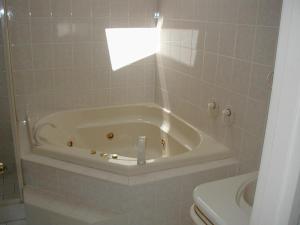 uma banheira branca na casa de banho com WC em Accommodation Sydney North - Forestville 4 bedroom 2 bathroom house em Forestville