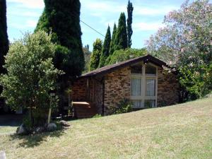 een klein stenen huis op een grasheuvel bij Accommodation Sydney North - Forestville 4 bedroom 2 bathroom house in Forestville