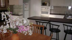 een keuken met een tafel met een vaas met bloemen erop bij Accommodation Sydney North - Forestville 4 bedroom 2 bathroom house in Forestville
