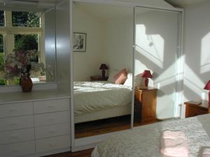 een slaapkamer met een spiegel, een bed en een dressoir bij Accommodation Sydney North - Forestville 4 bedroom 2 bathroom house in Forestville