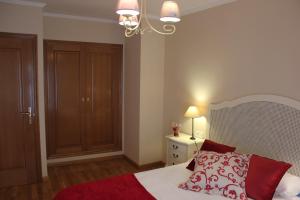 a bedroom with a bed and a chandelier at El Collado 17 in Soria