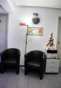 リスボンにあるLisbon Suite Homeの時計とクリスマスツリーのある待合室の椅子2脚