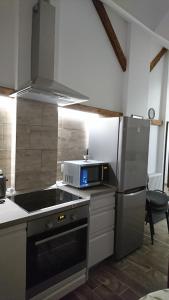 una cucina con frigorifero in acciaio inox e forno a microonde di Kisfaludy Sándor Apartman a Győr