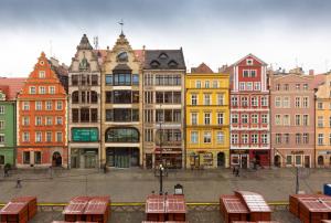 a group of buildings in a city with tables at LiPsTiCk HoUsE RyNeK in Wrocław