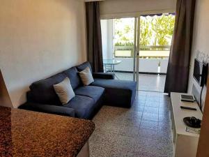 a living room with a blue couch and a table at 5 min walk from Yumbo 216 in Playa del Ingles