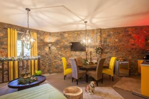 a dining room with a table and yellow chairs at Rock Dandy Mountain house - Παλιός Άγιος Αθανάσιος Καϊμακτσαλάν in Palaios Agios Athanasios