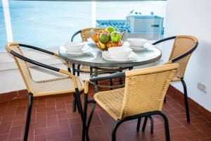 a table with chairs and a bowl of fruit on it at Mirador del Laguito 1201 in Cartagena de Indias