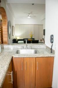 a kitchen with a sink and a living room at Mirador del Laguito 1201 in Cartagena de Indias