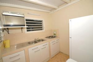 a kitchen with a sink and a microwave at LOUE F3 VUE SUR MER DANS PROPRIETE PRIVEE in Sainte-Anne