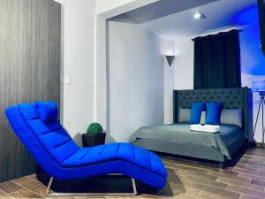 a bedroom with a blue chair and a bed at Modern Suite #1 Pasavento in Aguadilla