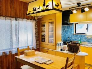a kitchen with a wooden table and a dining room at Midtown Sakura Apartment House 101 予約者だけの空間 A space just for you in Nachikatsuura