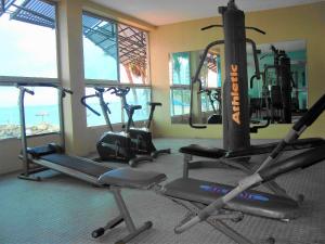 um ginásio com três bicicletas de exercício numa sala com janelas em Apartamento de Lujo al pie del mar Condominio Torre Marina em Salinas
