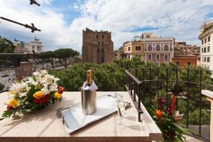 羅馬的住宿－羅馬諾酒店，阳台上的桌子上放着一瓶葡萄酒和鲜花