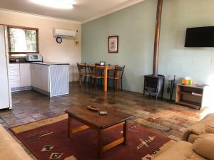 a living room with a table and a stove at Country Cottages of Bridgetown in Bridgetown