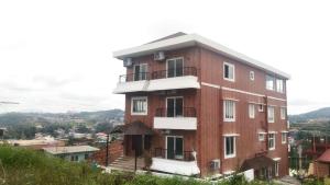 a large brick building on top of a hill at Lali Petals in Madikeri