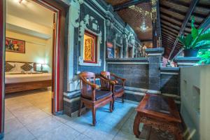 Cette chambre comprend une chaise, un lit et une table. dans l'établissement Tegar Guest House Ubud, à Ubud