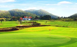 a view of a golf course with a green at Villa Bougainvillea in Hua Hin