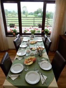 a dining room table with plates and utensils on it at Pensiunea Cetatea Craiului in Râşnov