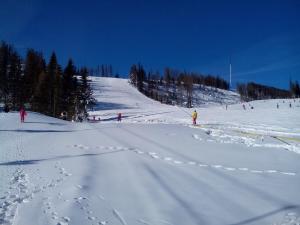 a group of people skiing down a snow covered slope at Panorama Apartmany in Štrbské Pleso