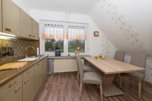 a kitchen with a wooden table and a window at Ferienwohnung Poppe in Loxstedt