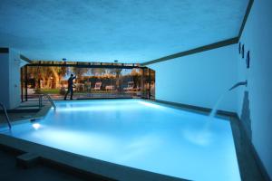 a swimming pool with blue lights in a building at Hotel Rabay in Brenzone sul Garda