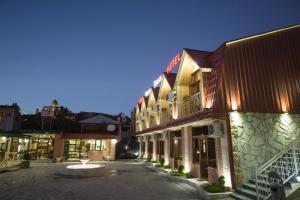 a group of buildings on a street at night at Hotel Dimasi in Kutaisi