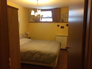 ロッカ・ディ・カンビオにあるAppartamento i Cerriのベッドルーム(白いベッド1台、窓付)