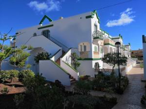 un edificio blanco con escaleras laterales en Estupendo Apartamento Gaudia, en Caleta de Fuste