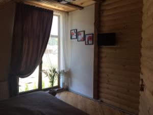 a bedroom with a bed and a large window at VIP House in Mykulychyn