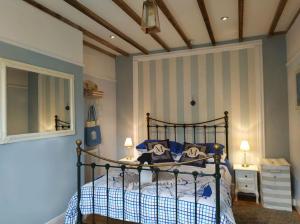 ein Schlafzimmer mit einem Bett und einem Spiegel in der Unterkunft dog friendly nancecliff cottages in Looe