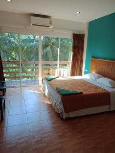 een slaapkamer met 2 bedden en een groot raam bij N.D.Hotel in Koh Lanta