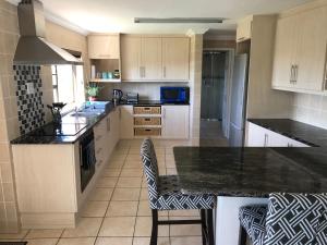 a kitchen with white cabinets and black counter tops at Sandy Bottoms in Jeffreys Bay