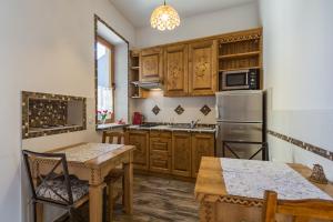cocina con armarios de madera, mesa y nevera en Pokoje i Apartamenty Krupówki 36, en Zakopane