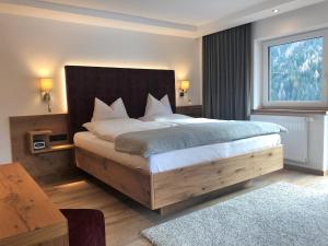 a bedroom with a large bed with a large window at Hotel Garni Central - Zimmer - Studios - Apartments in Kappl