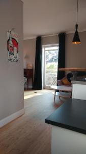 Apartment Leopold mit Balkon في كوبورغ: مطبخ وغرفة معيشة مع طاولة ونافذة