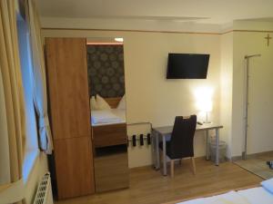 a room with a desk and a bedroom with a bed at Zum schwarzen Adler in Tulln