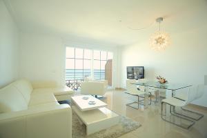 Biały salon z białą kanapą i stołem w obiekcie Apartment Minimal w Can Picafort