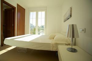 Un dormitorio blanco con una cama grande y una ventana. en Apartment Minimal, en Can Picafort