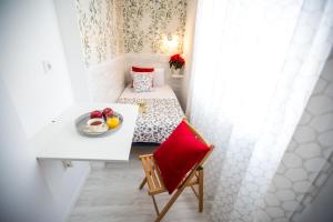 マドリードにあるBloom Inn Madridのベッド1台、テーブル(フルーツプレート付)が備わる小さな客室です。