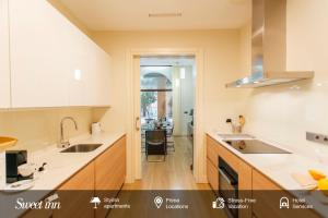 a kitchen with white counter tops and a sink at Alameda de Hercules Apartment in Seville