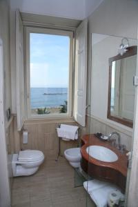a bathroom with a sink and a toilet and a window at Palazzetto Florio 1810 in Santa Maria di Castellabate