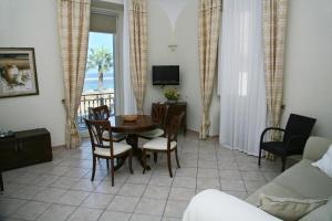 a living room with a table and chairs and a view of the ocean at Palazzetto Florio 1810 in Santa Maria di Castellabate